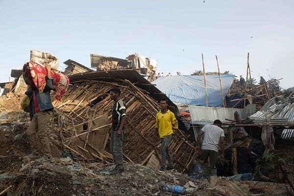 People move their belongings after dwellings built near the main landfill of Addis Ababa on the outskirts of the city were damaged in a landslide on march 12, 2017. PHOTO | ZACHARIAS ABUBEKER | AFP.